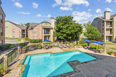 Sparkling swimming pool with lounge chairs at Bandera Crossing apartments in San Antonio, TX
